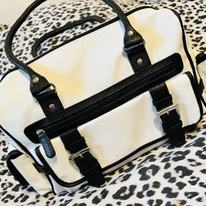 Super fin dam axel väska i skinn - Superfin dam axel väska i skinn.  Färg: svart/vit.   Flertal fack finns (plus inre fack).  Ej använd. Finns ej axelrem (kan köpas och användas) 