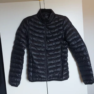 Svart dunjacka - Lätt svart dunjacka i bra skick! Stora fickor och inner fickor. Någorlunda åtsittande! Köpt på stadium och en jätte bra höstjacka eller vårjacka!