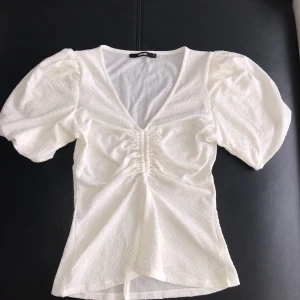 Vit topp/t-shirt - Supersöt vit topp med puffärmar.