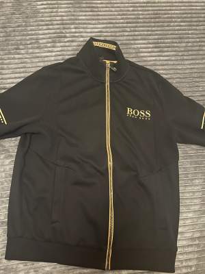 Hugo boss kofta i den gamla modellen då den dock inte säljs längre k Sverige knappt använd då den är för stor på mig (L) och har ingen användning av den.