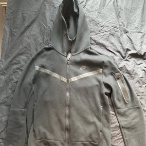 Nike tech tracksuit - Nike tech fleece tracksuit i färgen svart, storlek M. Brister i snörena på byxorna, annars är dressen i bra skick. Meddela för mer bilder/videos om önskas.