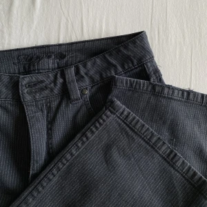 Byxor - Coola grå/vit randiga byxor med normalhög midja och raka ben. Lite slitna nere vid fållen (se bild) men annars finfint skick!