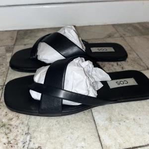 Cos sandaletter - I princip helt nya tofflor från cos. Äkta skinn. Säljer pga: Dem passar inte mina fötter tyvärr:/ 