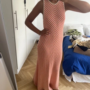 Stickad Maxi klänning från zara - En stickad maxi klänning från Zara!  I ett orange vitt mönster!  Stl XL men jag är en M i vanliga fall så passar även mindre storlekar!  Hellång (jag är 178cm)   Endast använd vid 1 tillfälle så den är i nyskick
