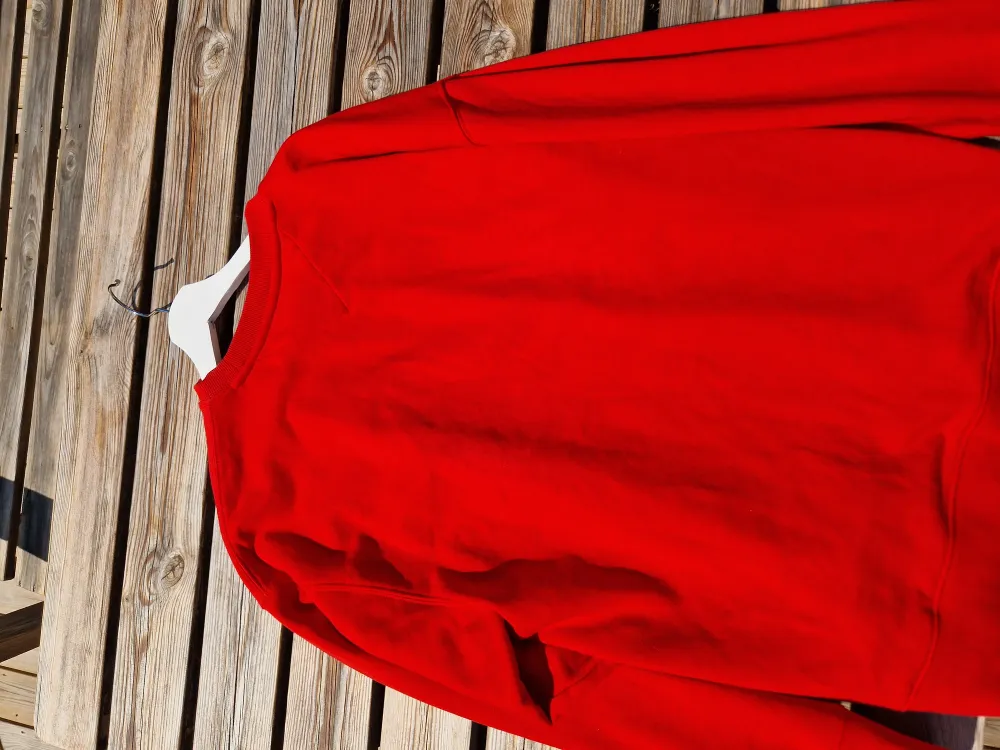 En snygg röd Tommy Tröja.  Finns en liten fläck på märket, därmed det billiga priset.  Skick 7/10. Tröjor & Koftor.