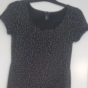 Svart prickig klänning - Söt skön bommullsklänning.  Svart med vita prickar. Slutar precis ovanför knäna. 