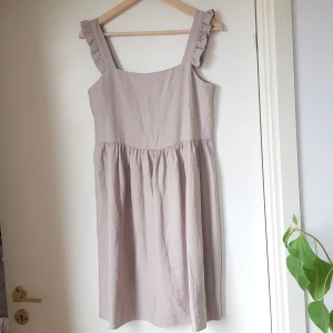 Beige sommarklänning - Nyskick, endast provad. Strl. 36. Beige sommarklänning med söta volang ärmar.