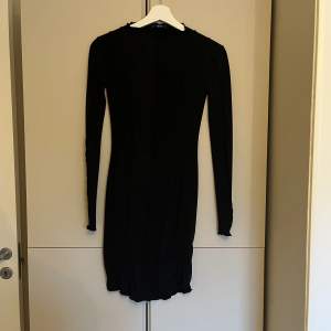 En svart klänning från Gina tricot i storlek xs. Klänningen har sömdetaljer längst hela klänningen och ärmarna. Är i väldigt bra skick då den endast är använd en gång. 