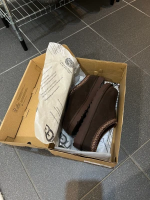Ugg Tasman - Helt nya ugg tasman i färgen Burnt Cedar. Storlek 37. Köpt på JD sport. Köparen står för frakten! Nypris:1300kr