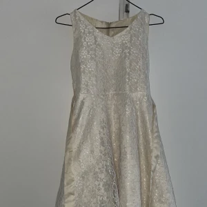 Vit spets barnklänning - Andvpnd ett fåtal gånger, inga fläckar eller hål. Klänningen har ett knytband.