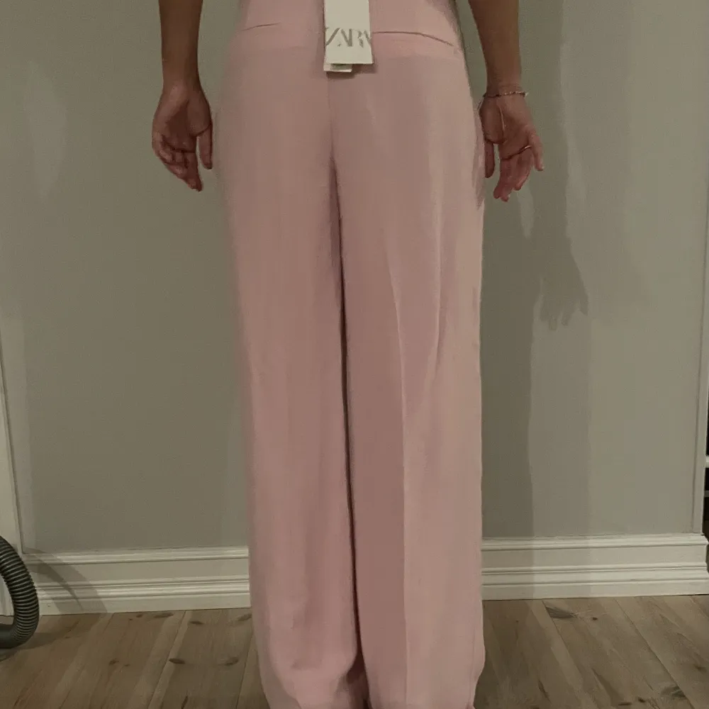 Rosa kostymbyxor från Zara säljer pågrund av att dom är får långa för mig. Byxorna är aldrig använda💗. Jeans & Byxor.