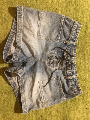 Low waist jorts - Coola jeans shorts med snörnings detalj och inga bakfickor😍 köpta på beyond retro💋 perfekt längd och superbra för sommaren/våren❤️kan mötas upp eller frakta (köparen står för frakt 💋