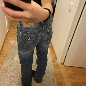 True religion - Säljer dessa lågmidjade jeans från True religion. Säljer pågrund av ingen användning. Köpt här på plick. Använd ett fåtal gånger av mig, dock så har dom hål längst nere på baksidan av byxan. Skriv privat för mer information/bilder. Möts bara upp!