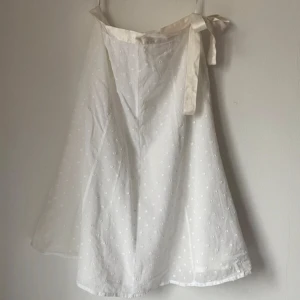 Vit långkjol - Så fin vit midikjol med ett band i satin vid midjan som knyts med en rosett därfram! Den är nyskick och bra kvalitet:) Skulle passa perfekt till tex student, skolavslutning eller midsommar! Har 3 för 2 på allt på min plick så gå gärna in o kika där också☺️