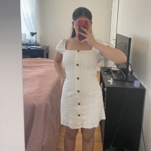 Vit klänning - Vit klänning från river island, perfekt för sommaren. Den är i storlek 4 så typ XS. Armarna går att ha som på första bilden eller offshoulder. 100kr + frakt. OBS! Knapparna går inte att öppna.