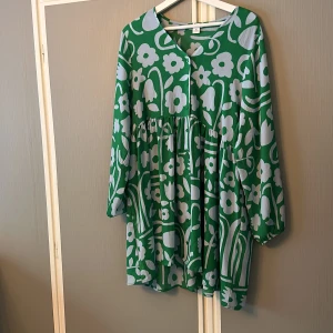 Kortare klänning - Kortare klänning i skitballt mönster. Blå/grått mönster med en grön bas. Använd fåtal gånger. (Frakt tillkommer) (lite större i Storleken)