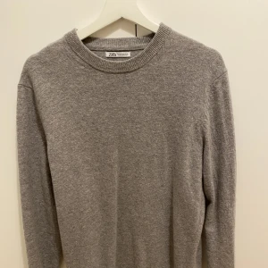 Grå sweatshirt Zara - En grå stickad sweatshirt från Zara. Storlek M. Tröjan är i nyskick då den tyvärr inte kommit till användning. Säljer för 150kr. Hör av dig vid frågor!