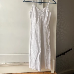 Linne klänning  - Klänning i linne mix med Blom detaljer nertill. 