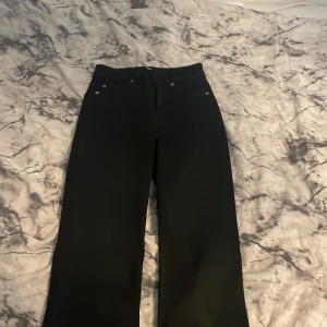 Jeans  - Svarta byxor me öppna ben längst ner.