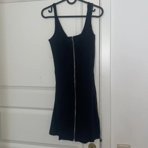 Klänning med drajkedja - Klänning med dragkedja framtill och spetsrygg! Strechigt material, tight passform