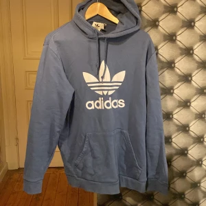 Adidas Blå Hoodie L - Schysst, sportig hoodie köpt direkt från Adidas hemsida så hög kvalitet. Använts sparsamt på grund av att jag knappt använder hoodies längre. Nypris 549 kr.