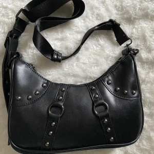 Väska - Snygg svart väska med detaljer som aldrig använts, det är justerbar i längden. Måtten är ca 25x10 🥰