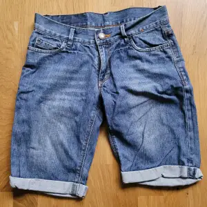 Blå jeansshorts med fickor fram och bak 