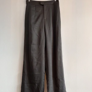 Gråa kostymbyxor utsvängda - Utsvängda grå glansigare byxor från typ chiquelle tror jag(?)