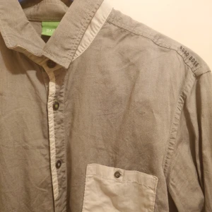 Beg Hugo Boss skjorta i bra skick  - Bättre begagnad Hugo Boss skjorta i grått med grön logga  Storlek Large   Mitt pris 99 kr plus frakt 