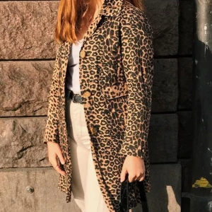 Leopardmönstrad kappa - Vintage kappa i leopardmönster med rosa innetyg. Fint skick. Passar S - M beroende på hur man vill att den ska sitta!