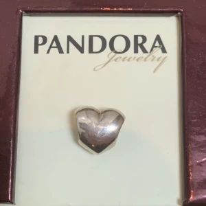 Pandora berlock nyskick  - Berlock i sterling silver,aldrig använt. Legat i original förpackning tillsammans med andra berlocker sen 2005/06. Ingen egen ask. Märkt 925/ALE (pandoras stämpel) Heter: PANDORA HEART STERLING SILVER CHARM BEAD #790137