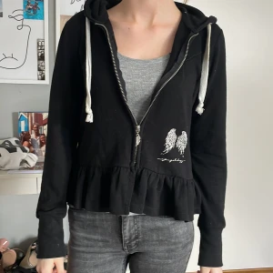 Svart tjocktröja - Jag säljer denna fina tröja, dem är svart med volanger där nere. Den är i mycket bra skick och säljer den för 100 kr