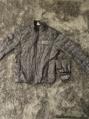EA7 vindjacka - Ea7 vindjacka köpt för 3 år sedan och använd väldigt lite  Hittar inte storlek på den men passar både  M och L, dock kan va lite stor på S 