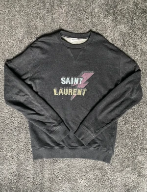 Saint Laurent swetshirt  - Säljer nu min Saint Laurent swetshirt ett litet hål vid armbågen! Använt skick men inga defekter som synd vid användning nypris ca 6000🙌
