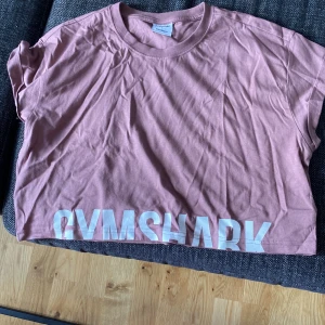 Gymshark crop top - Helt ny och oanvänd. Strl L men passar M också då de är små i strl. Oversize look. Dammrosa/brun färg.