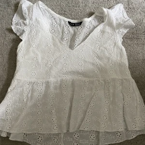 Jätte söt sommar topp - En vit blus aktig topp med blommor och volanger vid armarna. Säljer på grund av lite användning. Jätte söt på sommaren och passar till allt! 