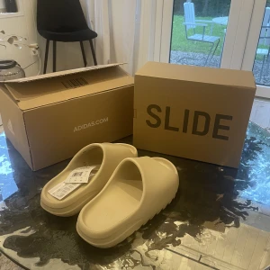 Yeezy slide bone - Helt nya och oanvända yeezy slides i storlek 44,5 (Inte ens testade). De är köpta på Adidas CONFIRMED från senaste droppet 3 augusti.   Fråga efter mer bilder och info ifall det önskas.  Frakt betalas av köparen.
