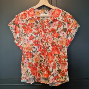 Oanvänd skjorta från Mango i blommigt mönster. Storlek M, sitter löst i modellen och är lite croppad, samt kortärmad