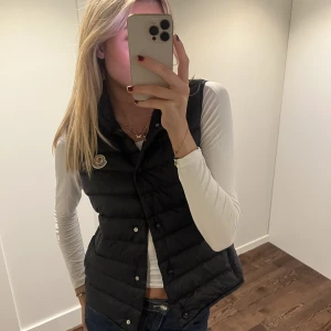 Moncler väst Liane - Säljer nu min superfina moncler väst då den inte kommer till användning. Västen är sparamt använd och är i mycket bra skick! Förvaringspåse till västen och prislapp ingår som äktenhetsbevis, det finns även ett ”chip” och en qr kod i västens innerlapp.