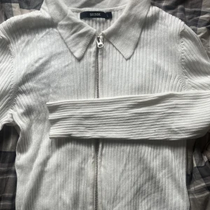 Kofta med dragkedja  - Tunn ribbad kofta från bikbok med krage och dragkedja. Passar både M/L 