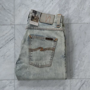 Helt nya Nudie Jeans ’Grim Tim’ - Säljer nu dessa helt sprillans nya Nudie Jeans i den eftertraktade modellen ’Grim Tim’ som har en slim-fit passform. Jeansen är helt nya utan defekter - Nypris: 1800 kr - Storlek: 30/34 - Hör av er vid minsta fråga eller fundering :)