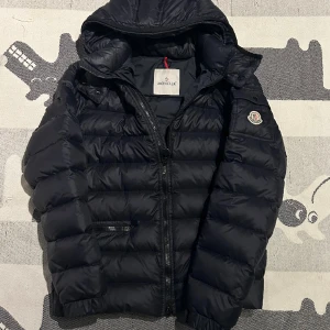 Moncler giubotto jacka🔥 - Moncler giubotto jacket , nästan helt ny !! 9,5/10 skick !! , inget og medföljs , Luvan är på ! Storlek 4 vilket motsvarar L men sitter mycket mer som en M-S !  , Unisex. || modellen är 185 ish ! Byter gärna !Pm frågor / funderingar !  Mvh