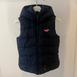 Hollister väst💙💘 - Säljer en mörkblå Hollister väst med lite rosa detaljer. Säljer pågrund av att den inte kommer till användning längre. Nypris vet jag tyvärr inte men runt 600-700kr typ. Skriv för fler frågor eller bilder💘💙