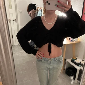 Snygg svart stickad tröja - Jätte cool väldigt croppad övertröja som är jätte snygg att ha över ett linne eller t-shirt! 