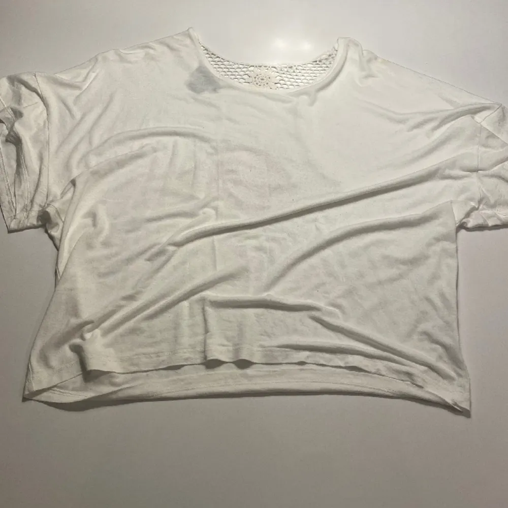En vit t shirt med mönster bak! Ser kortare ut på bilden än vad den är. Tröjan är knappt använd och i bra skick!. T-shirts.