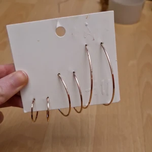 Örhängen - 3 st par örhängen, guldiga ringar. Helt nya, i sin originalförpackning.