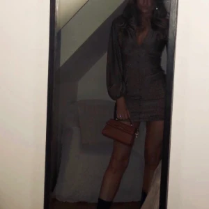 Glitterklänning - En glitterklänning från asos i strl 38 man får en fin figur är i brunsvart, är i bra skick använd fåtal gånger