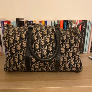 Dior väska - Säljer väääärldens finaste väska från Dior i bostonmodell. I mörkblått och beige med monogram-mönster. Min mormor köpte denna i Frankrike på 80-talet, så den har ett par år på nacken men är fortfarande i fint skick. 🖤🖤 Skriv vid frågor 