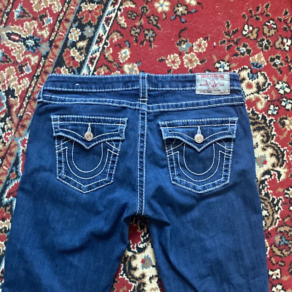 Säljer sjukt snygga blåa true religion jeans i storlek 33. Aldrig använda, köpta second hand :) Modellen är skinny och lågmidjade. Bakfickorna har knappar. Midjemått 45 cm tvärsöver, innerbensmått 78 cm🫶🏼 . Jeans & Byxor.
