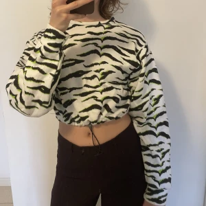 Zebra tröja - Cool fleecetröja i zebramönster med gröna detaljer. Går att spänna åt i midjan eller ha löst💕